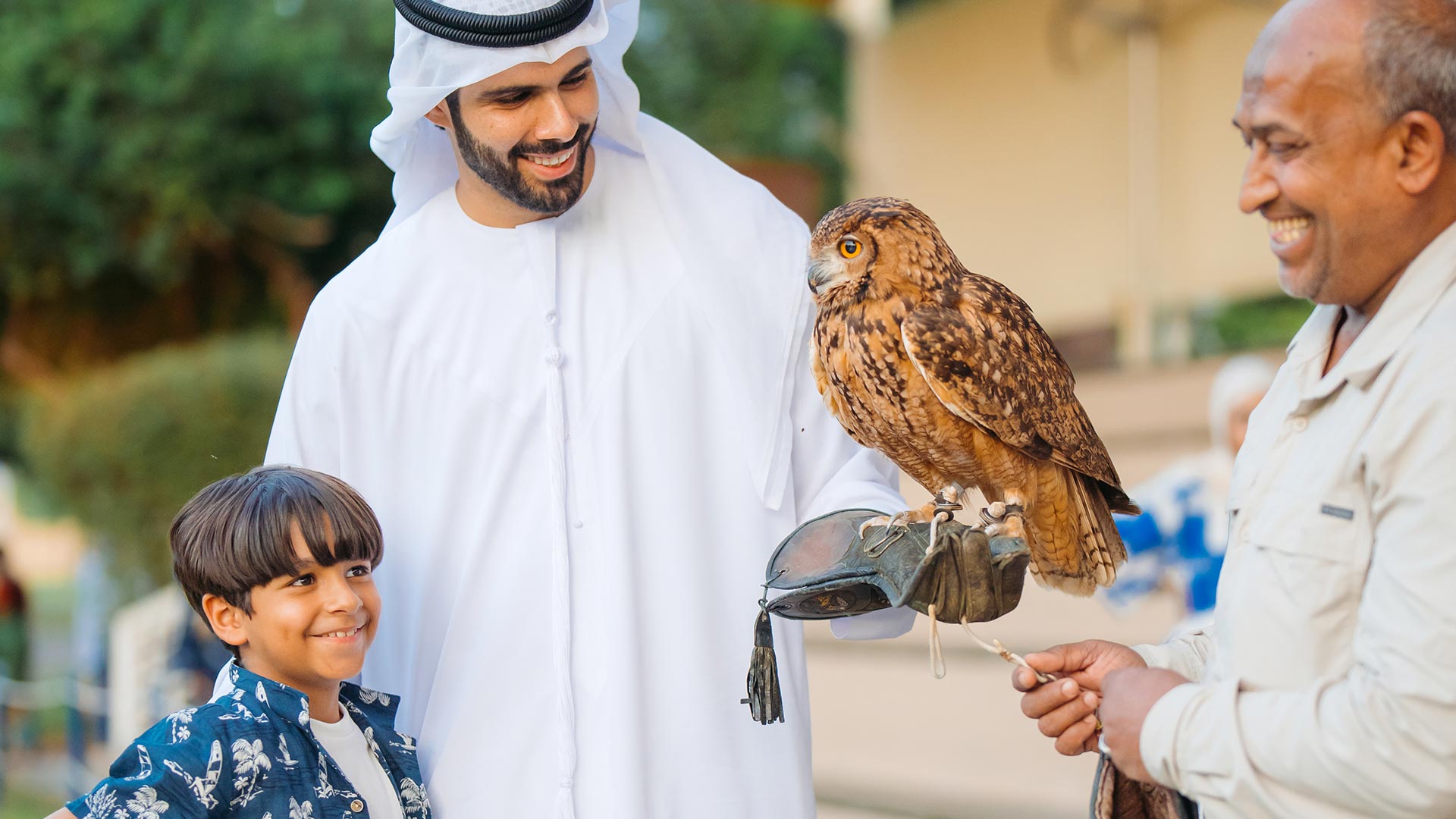 Father and son holding an own together with an animal care specialist at Al Ain ZooFather and son holding an own together with an animal care specialist at Al Ain Zoo