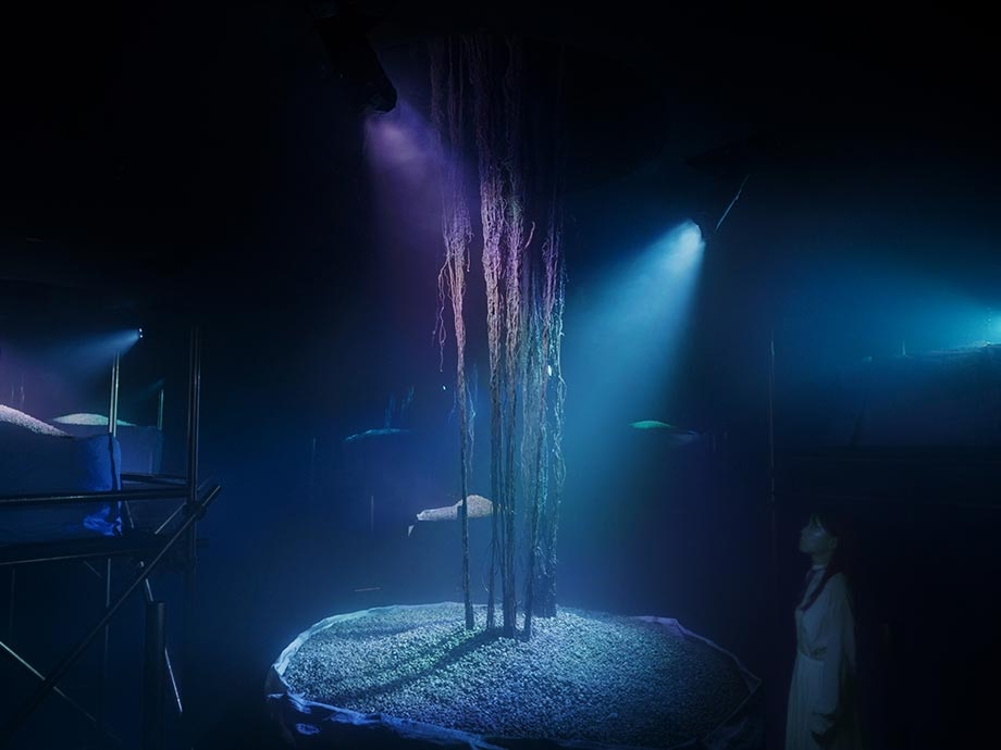 Live roots highlighted with blue lights underneath the artwork