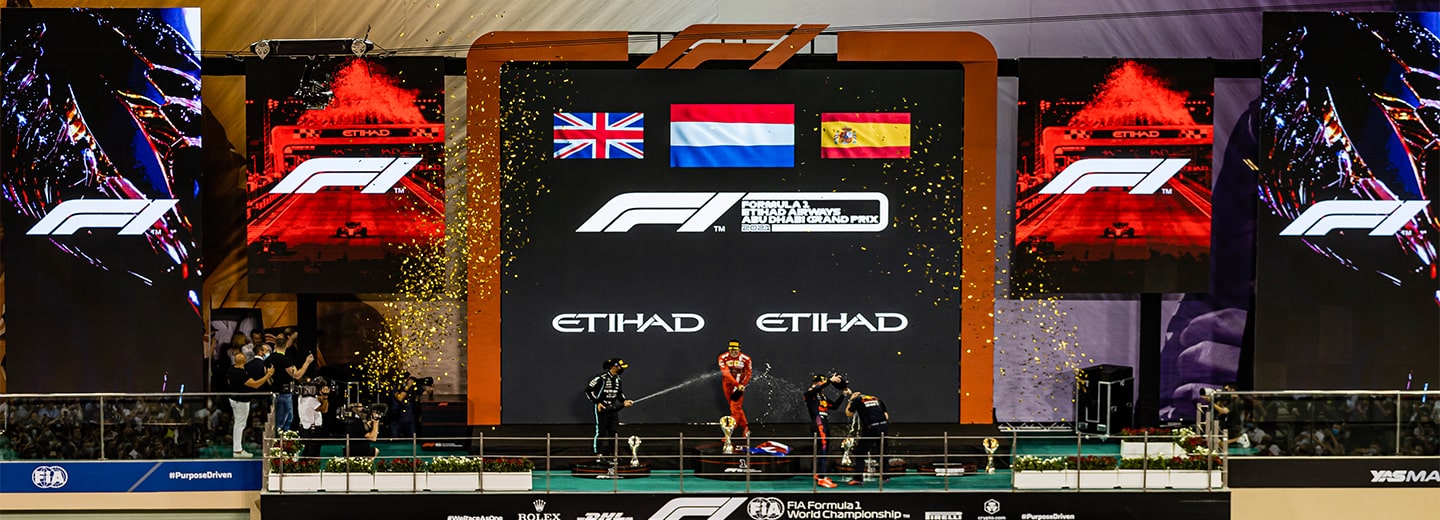 View of an F1 winning team standing on the podium during a ceremony.