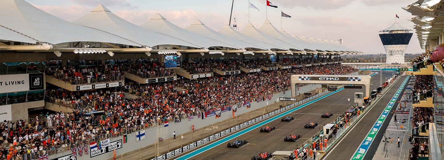 F1 cars lined up in the starting grid, between the main grandstand at Yas Marina Circuit, Abu Dhabi